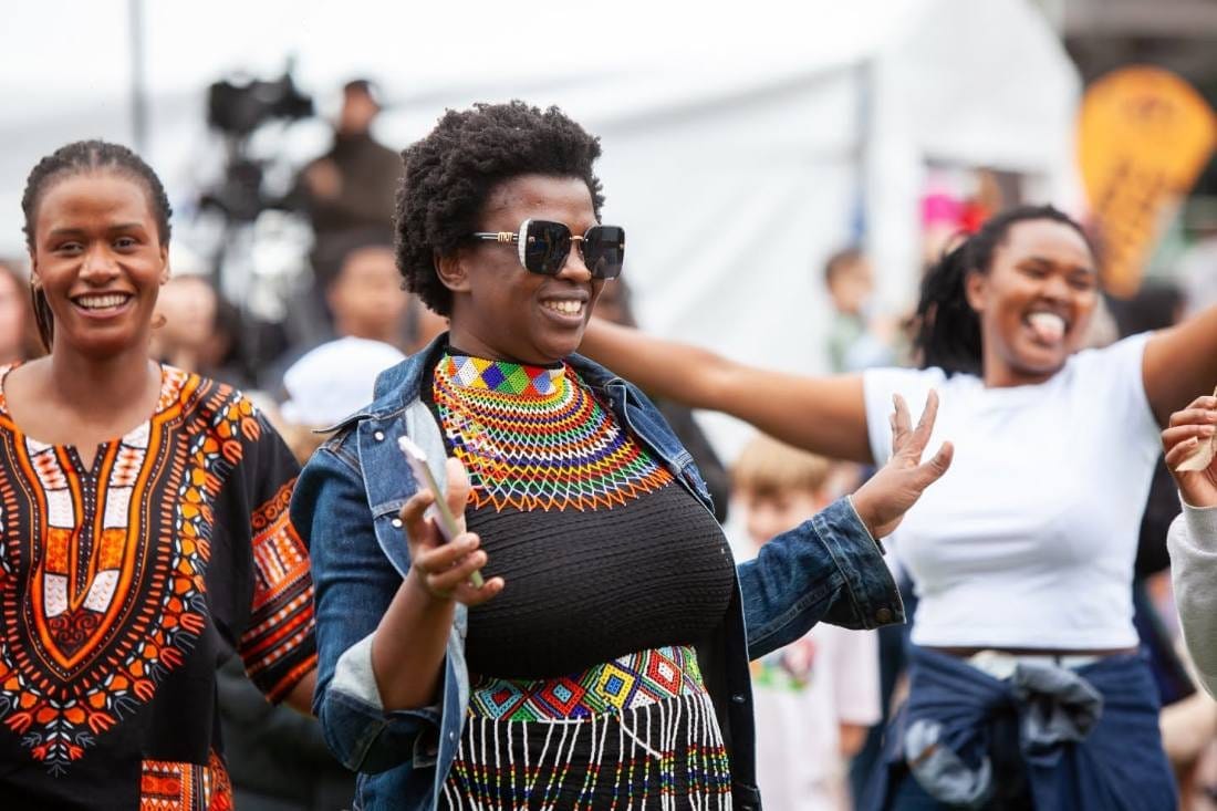Women dancing and smiling in the crowd at the African Music and Cultural Festival at Fed Square